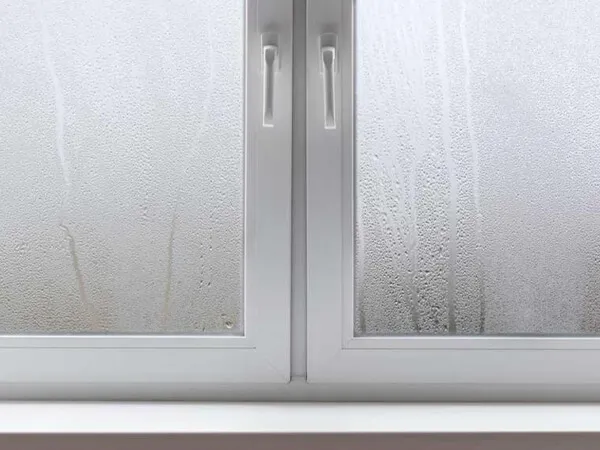 A white UPVC window with condensation on it