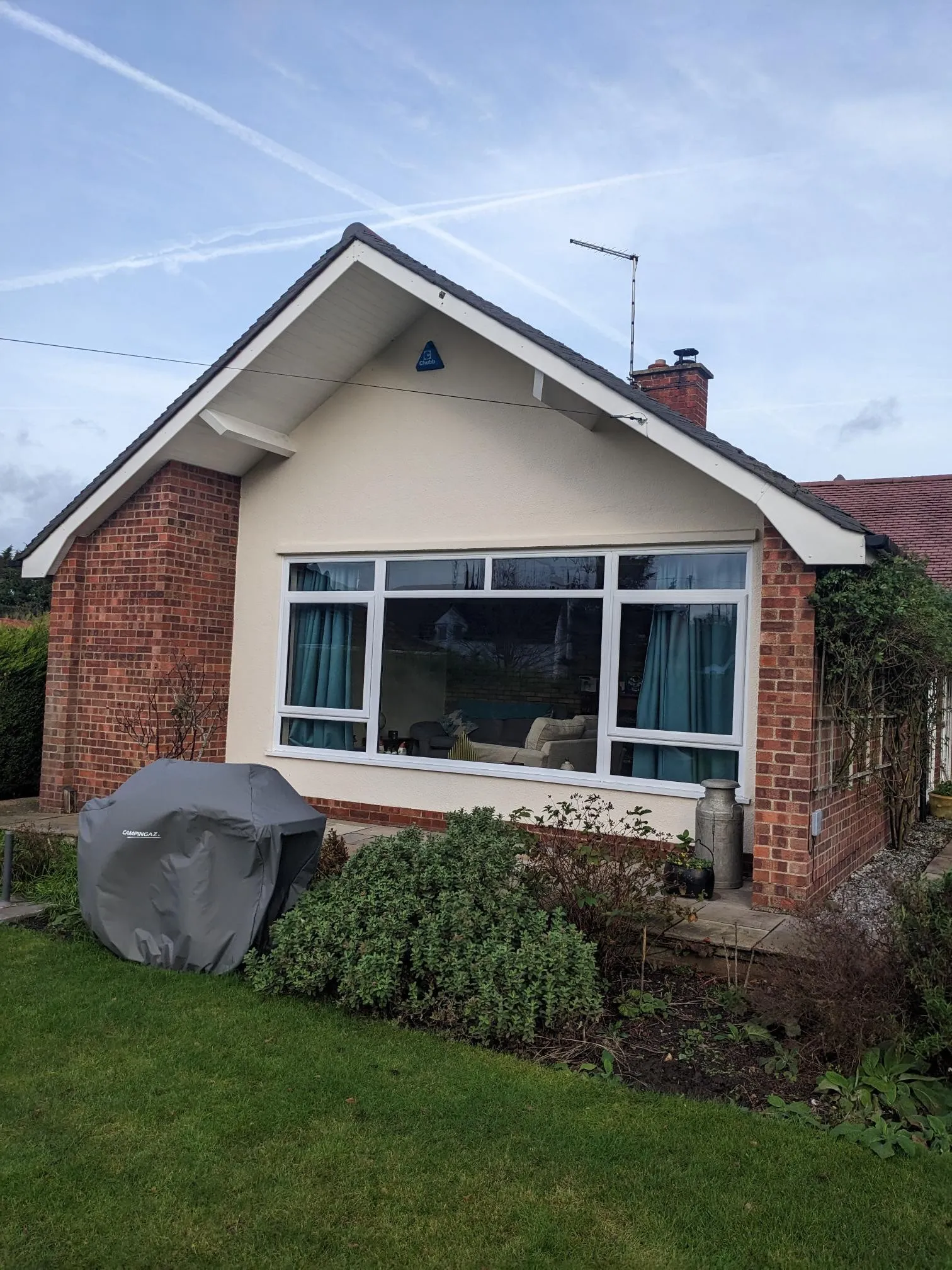 White uPVC casement in a cream rendered gable before aluminium gable glazing, Blofield NR13