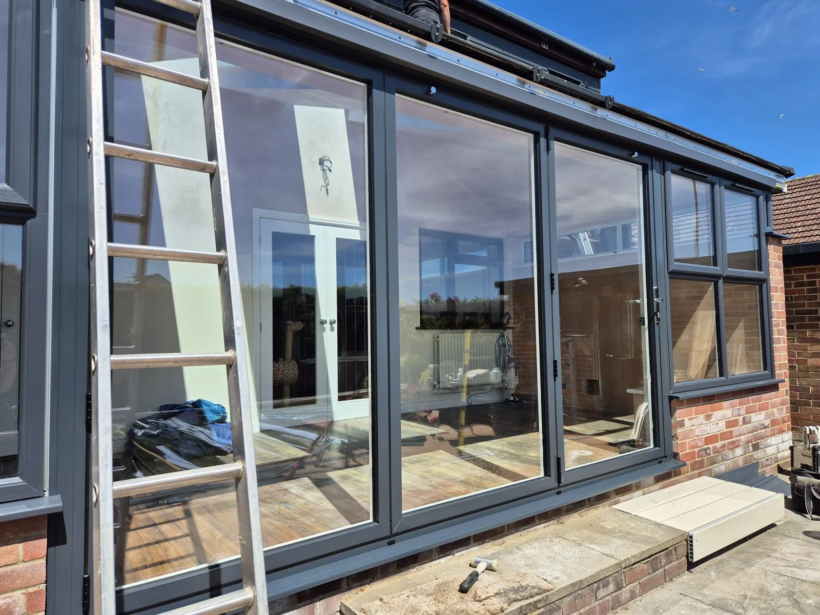 Anthracite patio doors and windows fitted with new grey cladding above