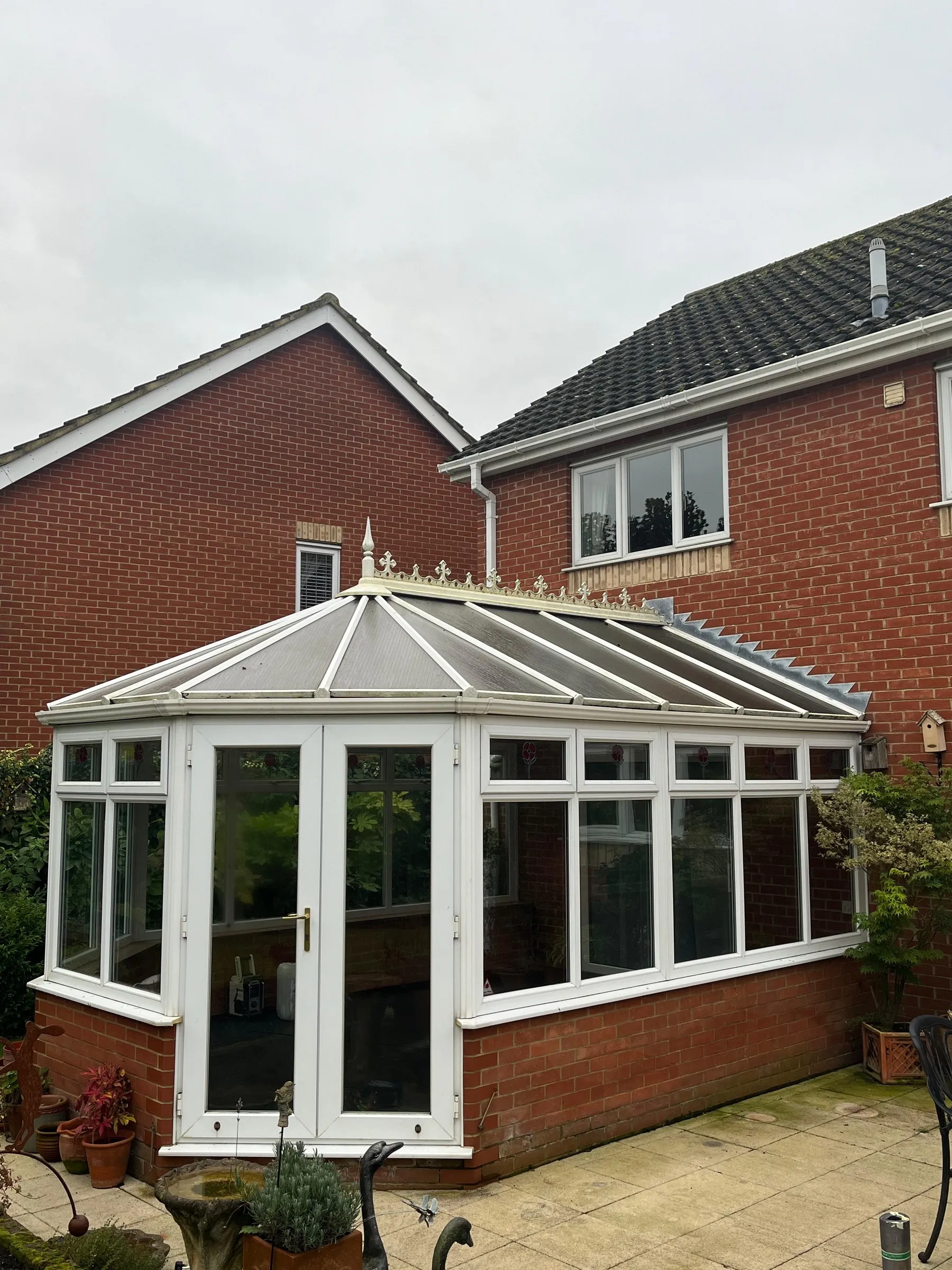 Before: Victorian conservatory with weathered polycarbonate roof and white uPVC French doors, Dereham NR20