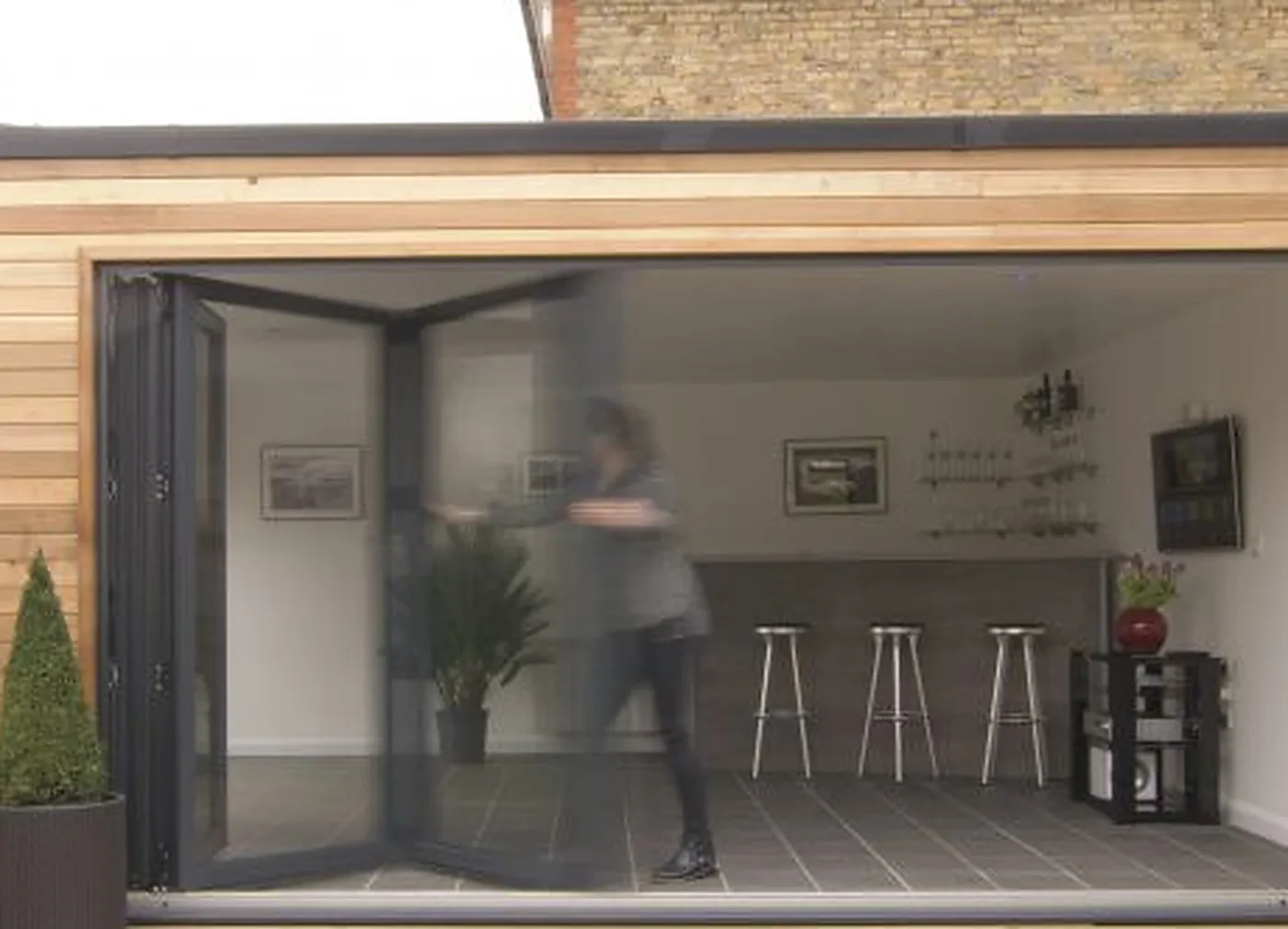 Interior of Drayton NR8 garage conversion seen through open anthracite bi-fold doors, finished plastered room