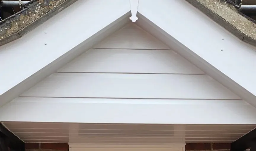 Porch gable with new white cladding, white fascia boards and soffit above a front door in Drayton NR8