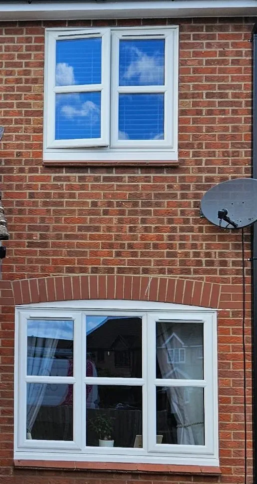New white uPVC casement windows on the front of a brick house in Drayton NR8, upstairs and on the ground floor