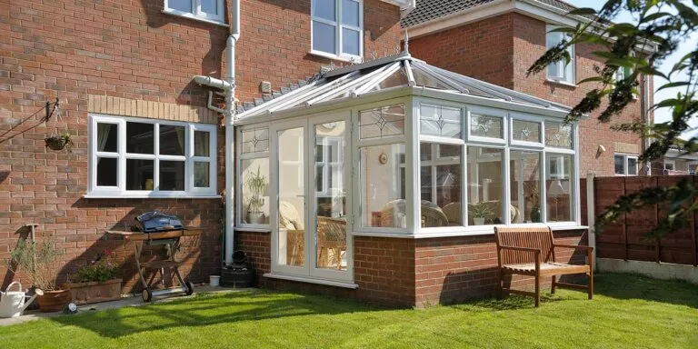 White Edwardian conservatory with a square front on a brick dwarf wall