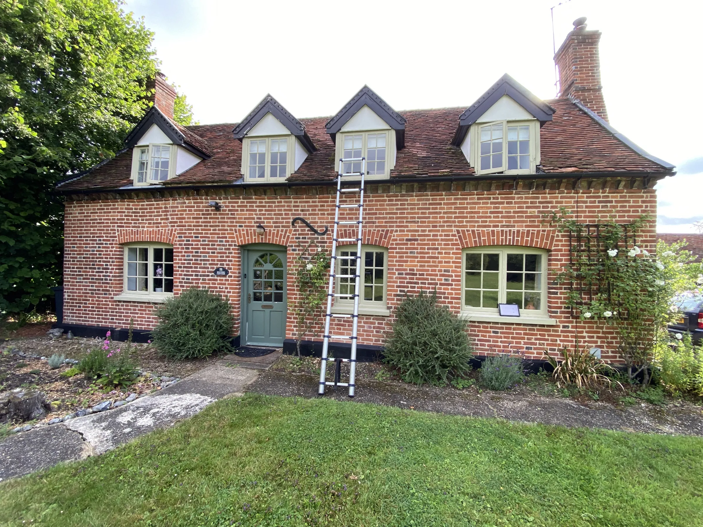 Before: sage-green timber casements and timber front door on Old Rectory Cottage, Langham IP31