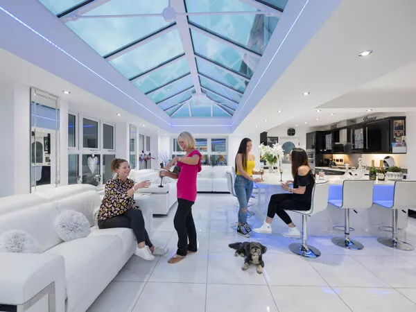 Inside an orangery looking up at a large glazed roof lantern over a kitchen and family area