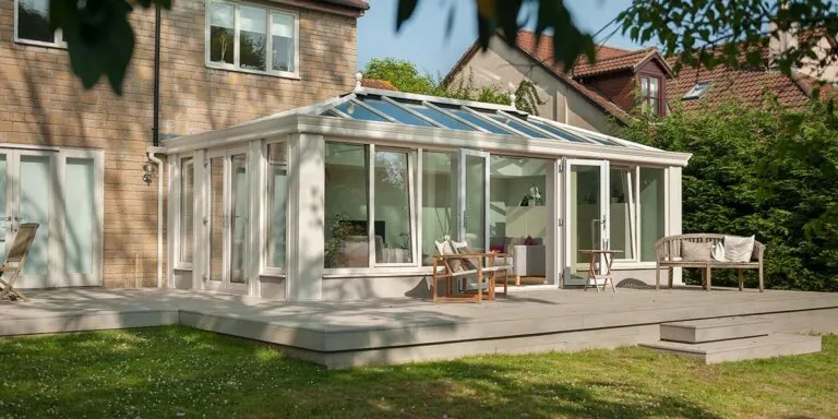 Cream loggia-style conservatory with solid pillars and wide glazed openings