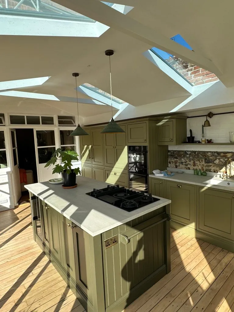 Kitchen extension with green cabinets and roof lights replacing an old conservatory on a listed home in Loddon