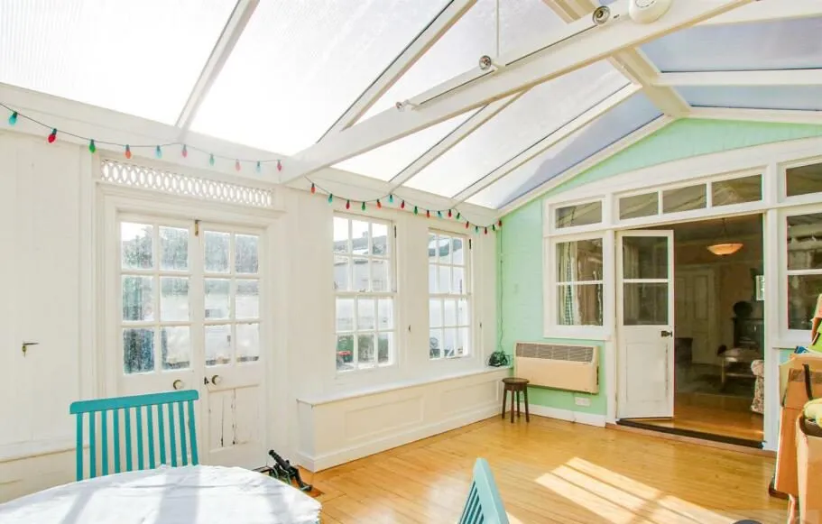 Interior of old timber conservatory in Loddon, Norfolk with polycarbonate roof and dated glazing, photographed before orangery replacement and kitchen extension