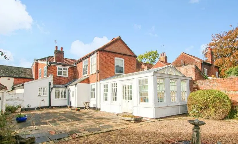 Exterior of old timber conservatory in Loddon, Norfolk with polycarbonate roof, photographed before orangery replacement and energy-efficient kitchen extension