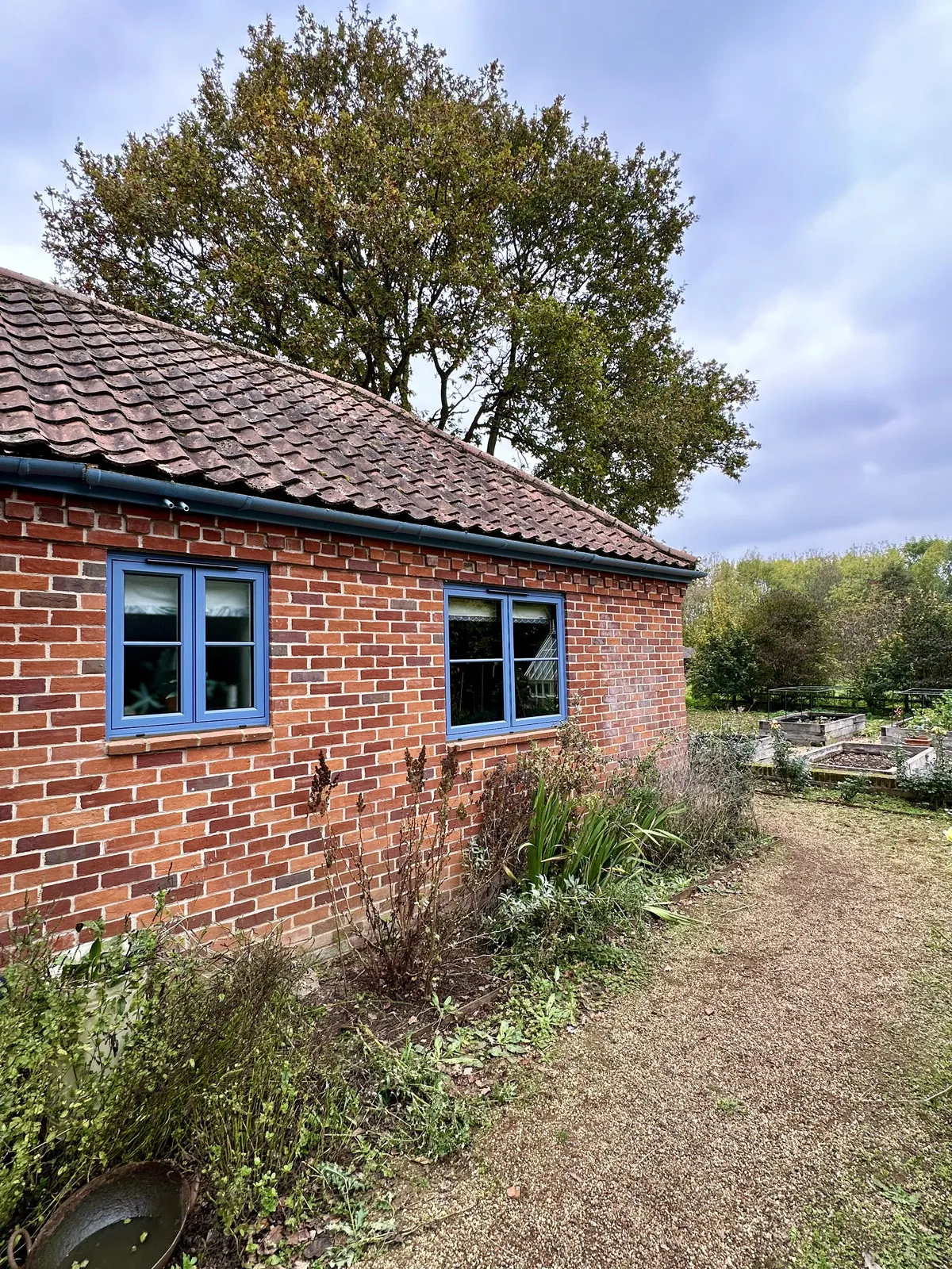 Detail of duck-egg aluminium flush casements with Georgian bar in red brick, Mulbarton NR14