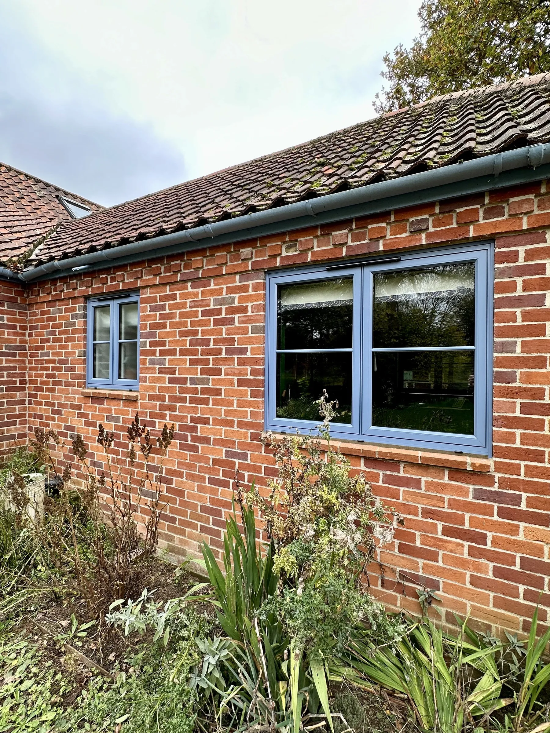 Aluminium flush casement windows in duck egg blue on red brick at The Old Hall, Mulbarton NR14, after installation by Amber Home Improvements