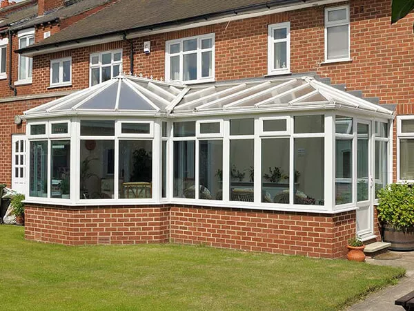 White P-shaped conservatory combining a lean-to section with a rounded end