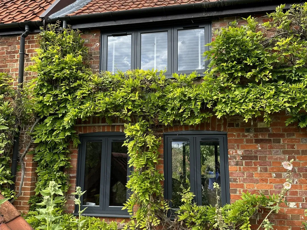 Anthracite grey flush casement windows and French casements on a red-brick farmhouse in Welborne NR20