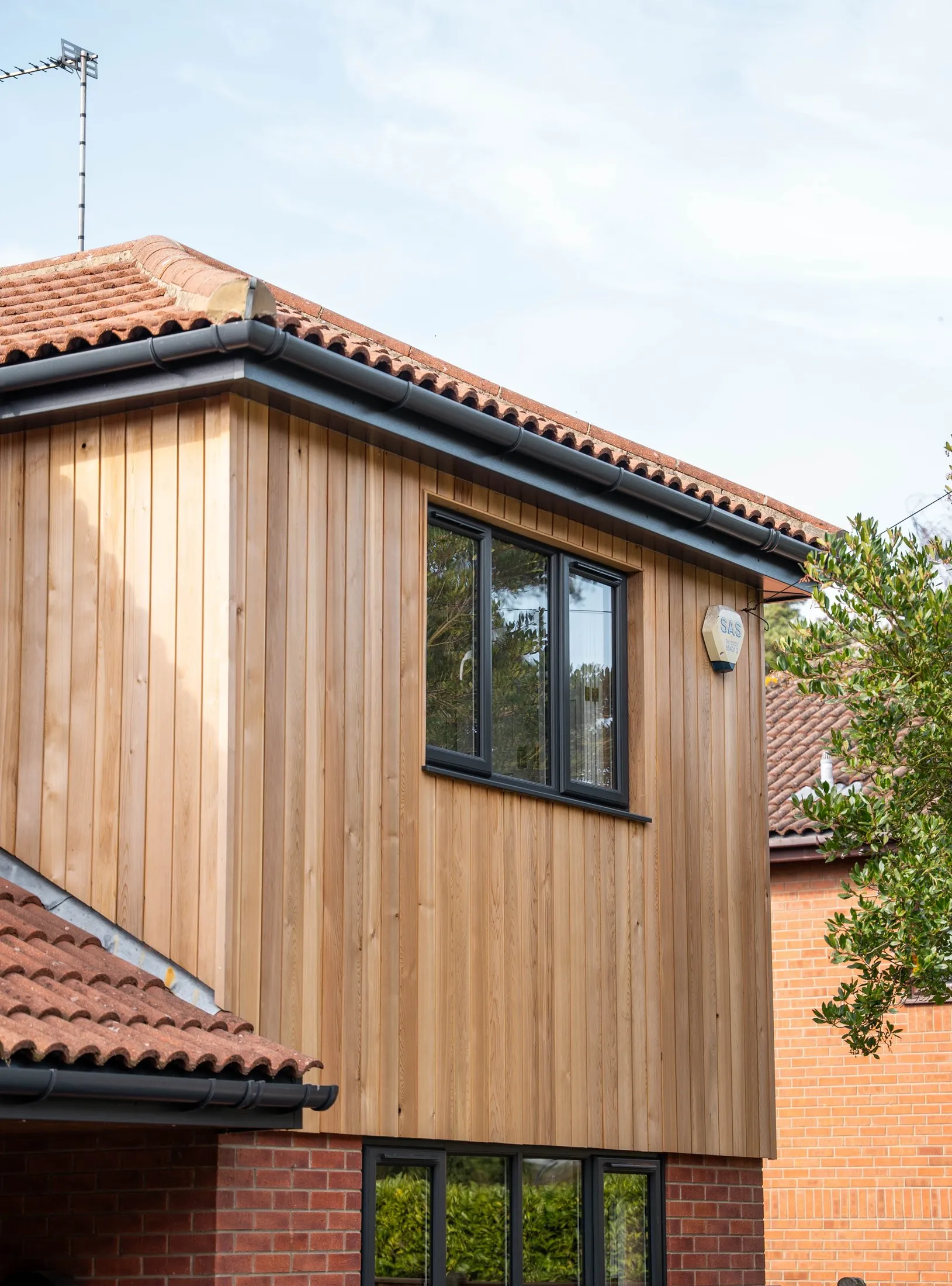 Vertical red cedar cladding wrapping the first-floor corner of a St Olaves NR31 home