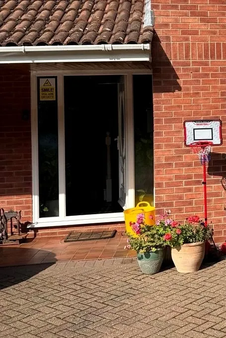 Before: white uPVC front door and side panel on a red-brick porch in St Olaves NR31