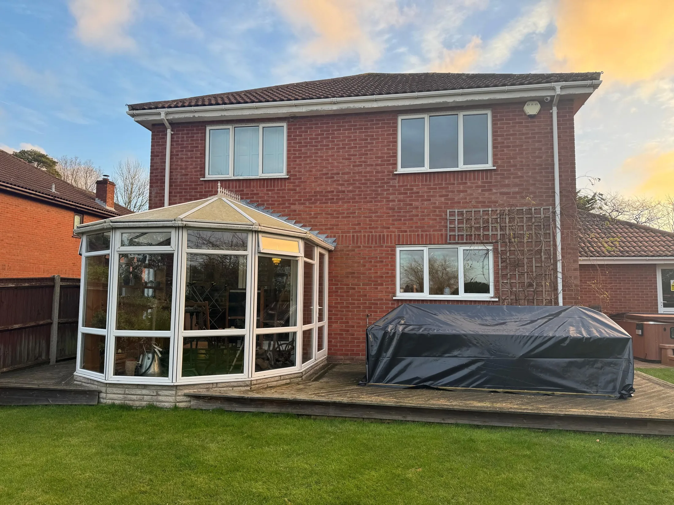 White glass conservatory on the old decking at the rear of a St Olaves NR31 home, before the brick extension