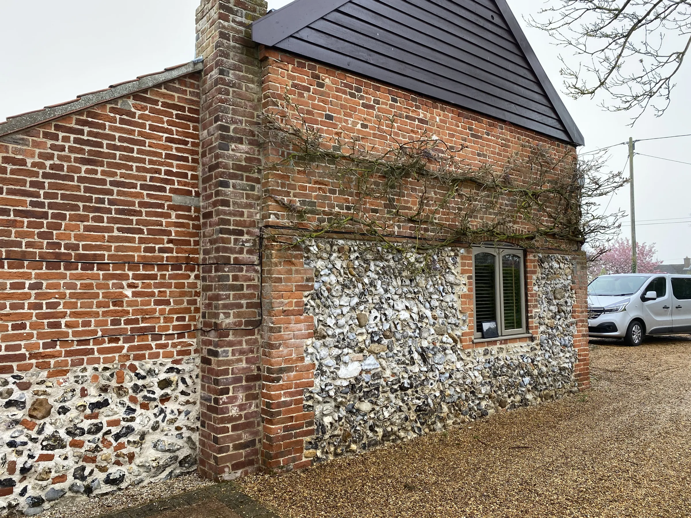 Before: painted sage-green casement in flint and brick side elevation, Welborne NR20