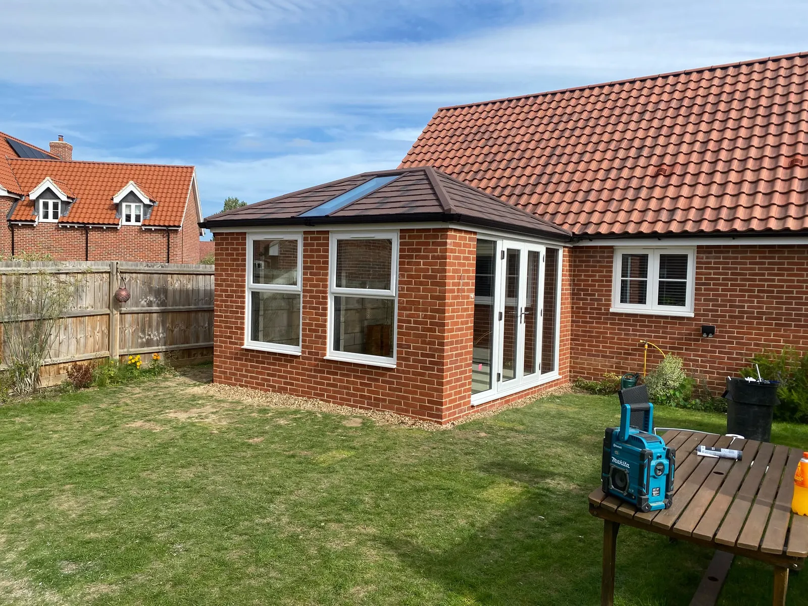 After: red-brick rear extension with Ultraroof solid tiled roof, roof light, white French doors in a brick loggia, Woodbridge IP13