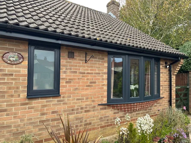 Anthracite grey flush casement bow window installed by Amber Home Improvements on a bungalow in Wymondham, Norfolk.