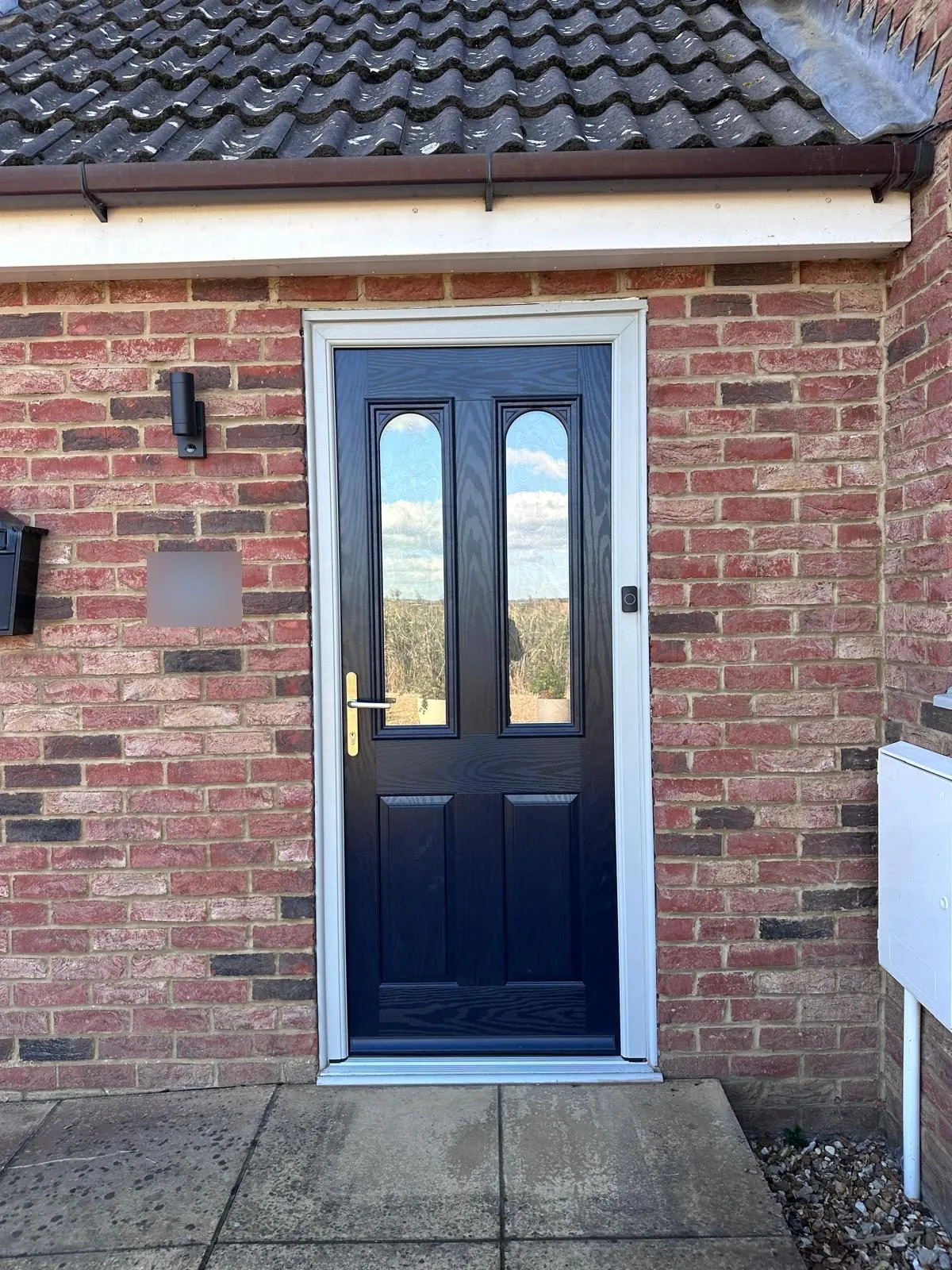 Close view of the new blue four-panel composite door with curved glazed top panels and an agate grey frame, Downham Market area