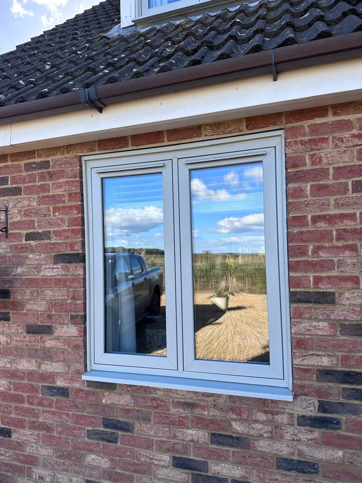 Agate grey flush casement window with two opening sashes in a red brick wall, Downham Market area