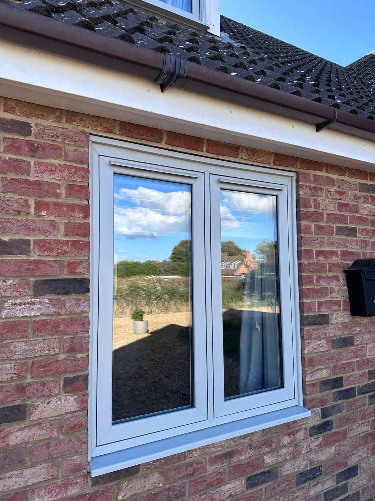 Agate grey flush casement window with trickle vent and white interior frame