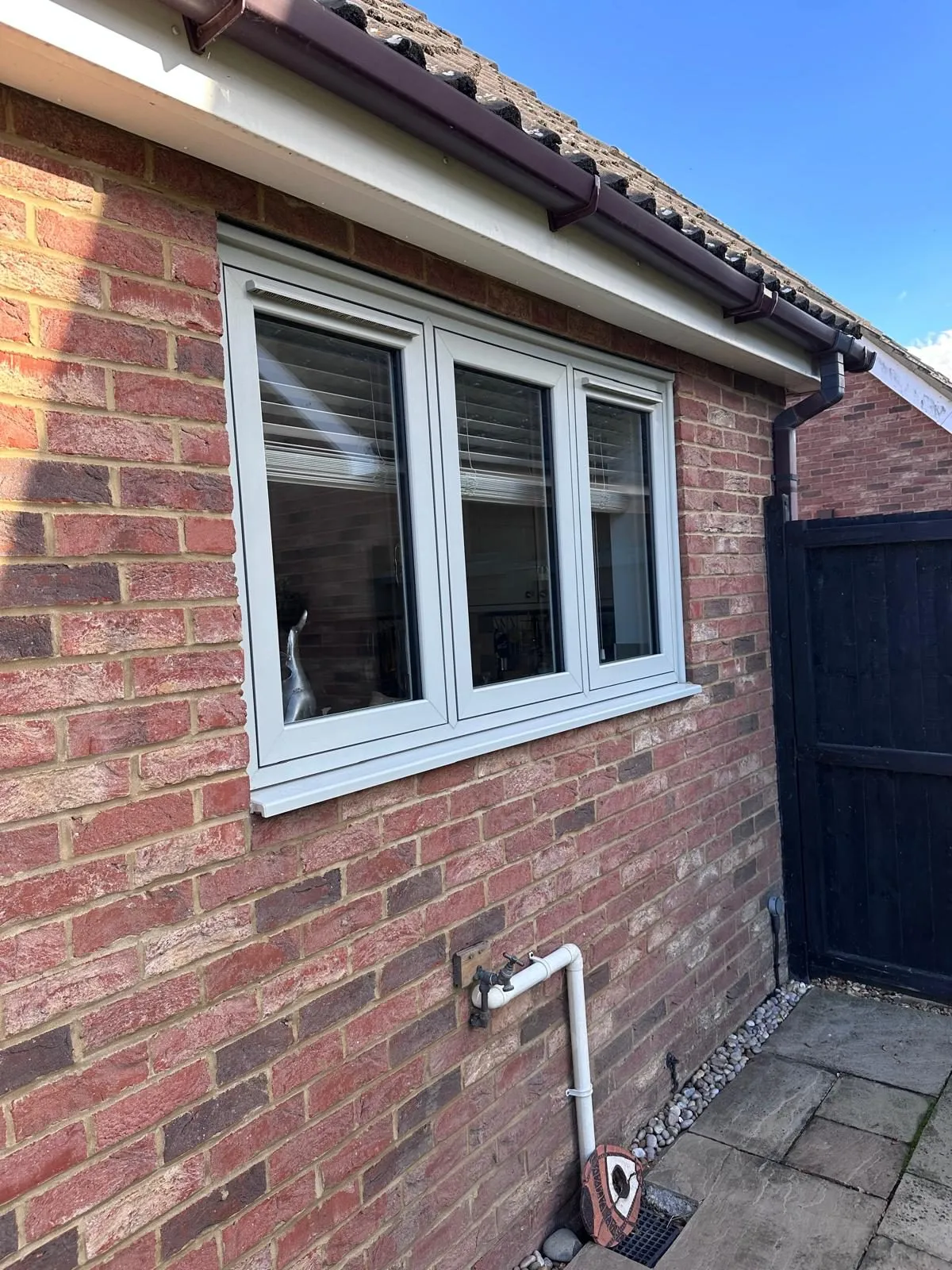 Agate grey flush casement window on the rear corner of a red brick home, Downham Market area